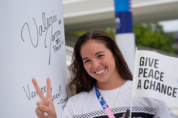 Palestinian-American swimmer Valerie Tarazi flashes a peace sign during the inauguration of the Olympic Truce Wall in the Olympic Village on July 22, 2024, in Paris. (David Goldman/AP)