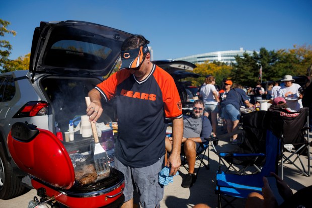 Randy Gohmann grills burgers while tailgating before the Bears play the Broncos on Oct. 1, 2023, at Soldier Field. (Armando L. Sanchez/Chicago Tribune)