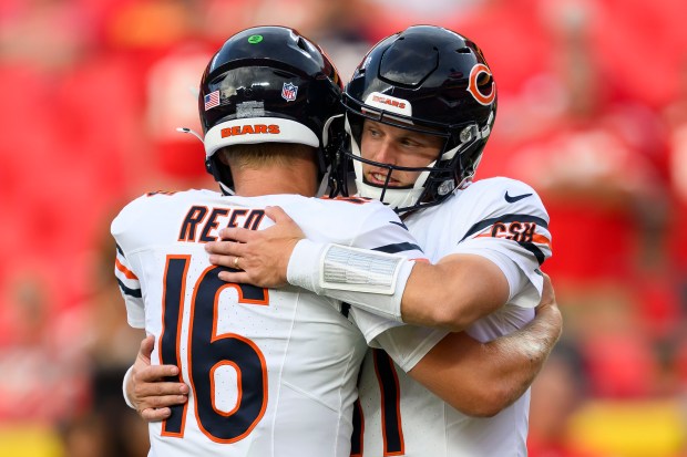 Chicago Bears quarterback Austin Reed (16) hugs Bears quarterback Brett Rypien, right, during warmups before an NFL preseason football game against the Kansas City Chiefs, Thursday, Aug. 22, 2024 in Kansas City, Mo. (AP Photo/Reed Hoffmann)