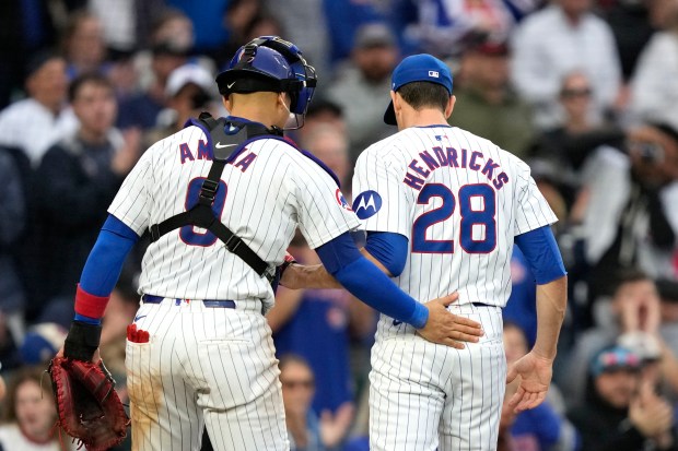 Cubs catcher Miguel Amaya pats starting pitcher Kyle Hendricks on the back after the top of the seventh inning against the Reds on Sept. 28, 2024, at Wrigley Field. (Charles Rex Arbogast/AP)