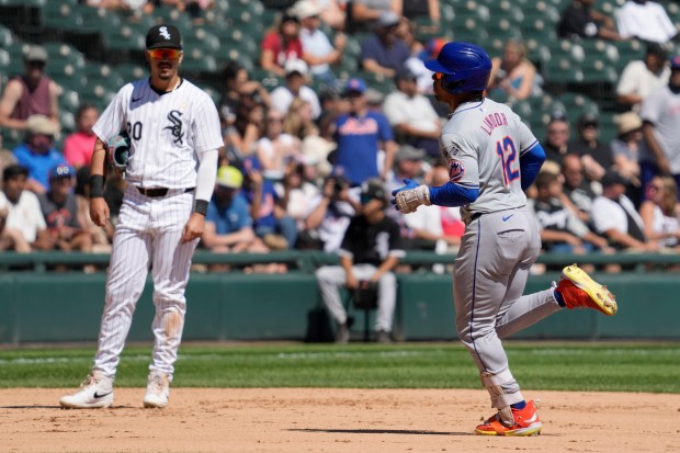 New York Mets' Francisco Lindor, right, rounds the bases after hitting a solo home run as Chicago White Sox third baseman Miguel Vargas, left, looks on during the fourth inning of a baseball game in Chicago, Sunday, Sept. 1, 2024. (AP Photo/Nam Y. Huh)