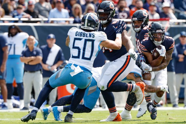 Chicago Bears wide receiver DJ Moore (2) runs with the ball as guard Nate Davis (64) blocks against Tennessee Titans linebacker Jack Gibbens (50) during the first half of an NFL football game, Sunday, Sept. 8, 2024, in Chicago. The Bears defeated the Titans 24-17. (AP Photo/Kamil Krzaczynski)