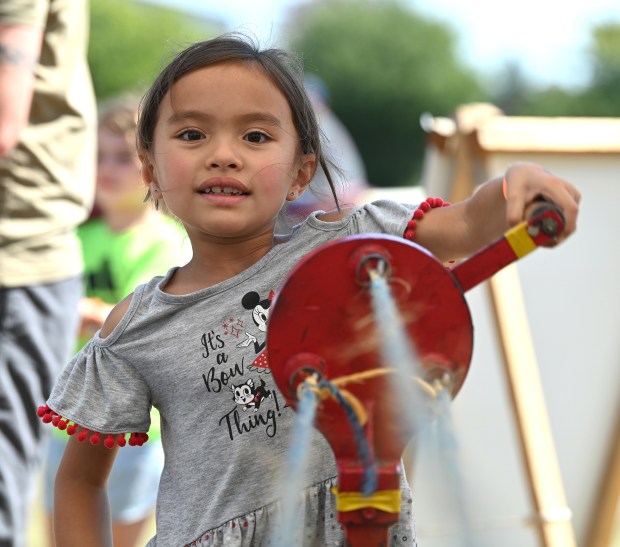 Leilani de la Paz, 6, a first-grader from Gurnee makes a jump rope with a heritage rope making crank at Fall on the Farm at Lambs Farm in Libertyville on Sept. 14, 2024. (Karie Angell Luc/Lake County News-Sun)