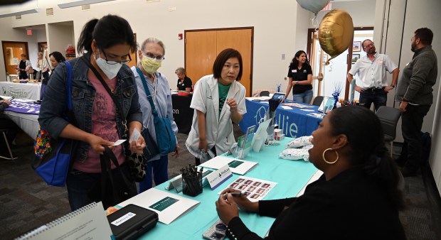 Seated on right, Sheri Smith, practice manager of operations for Briarwood Park Dental Care of Deerfield, engages with patrons at the Healthy Lifestyle Expo on Sept. 7, 2024 in Deerfield at the Patty Turner Center. (Karie Angell Luc/Lake County News-Sun)