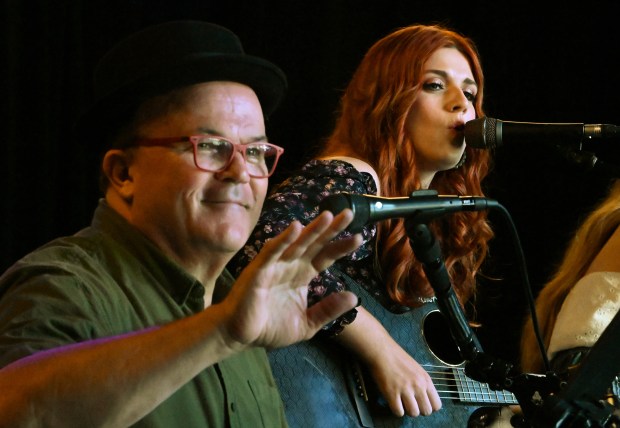 Left, musician Stan Karcz waves at a fan in the audience while Payton Taylor performs as part of the Writers Circle during Nashwood at 28 Mile Vodka Co. on Aug. 31, 2024 in Highwood. (Karie Angell Luc/Lake County News-Sun)