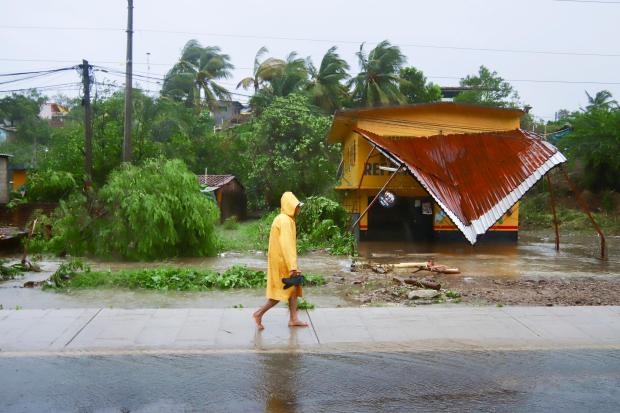 A person walks in the rain after the passing of Hurricane John in Marquelia, Mexico, Tuesday, Sept. 24, 2024. (AP Photo/Luis Alberto Cruz)