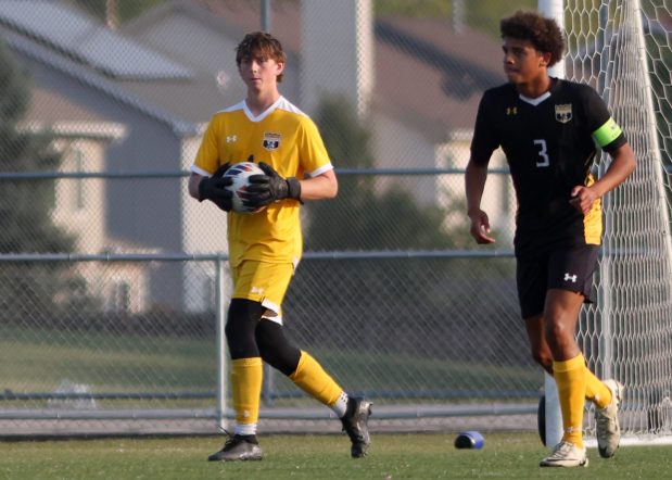 Metea Valley's Patrick Maroney, left, holds the ball alongside teammate Anthony Hildreth (3) after making a save against Hinsdale Central during a nonconference game in Aurora on Wednesday, Sept. 11, 2024. (Troy Stolt / Naperville Sun)