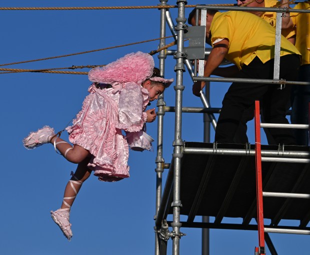 The pink angel, Chloe Hartl, 10, a fifth-grader from Round Lake, returns to the scaffolding platform during the Flight of the Angels at the Religious Feast of Maria SS Lauretana of Altavilla Milicia in Niles on Sept. 1, 2024. (Karie Angell Luc/Pioneer Press)