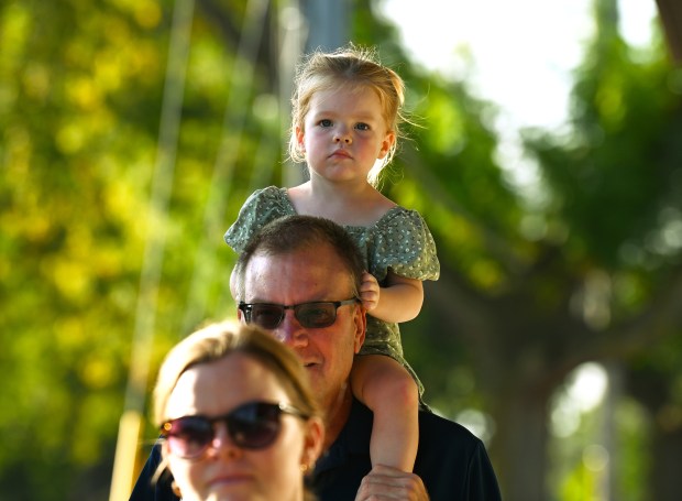 Brian Blume of Lake Zurich, of the Lake Zurich High School Class of 1982, holds granddaughter Ava Cordes, 2, of Vernon Hills at Rock the Block on Saturday, Sept. 14, 2024 in downtown Lake Zurich. (Karie Angell Luc/Pioneer Press)