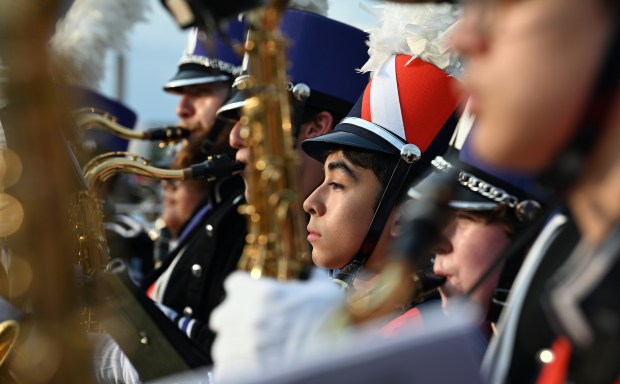 Wearing the plume orange hat of the Evanston Township High School Wildkits marching band is ETHS freshman Alan Bautista, a tenor saxophonist, while lined up with the Northwestern University marching band during the annual 'Kits, 'Cats & Kids Block Party on Thursday, Sep. 5, 2024 at the Evanston Township High School Lazier Field in Evanston. (Karie Angell Luc/Pioneer Press)