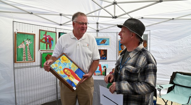 From left, Mundelein Mayor Steve Lentz with purchase award artist Shawn Killackey of Mundelein at the 13th Mundelein Arts Festival, an annual juried festival on Sept. 7, 2024 in Mundelein. (Karie Angell Luc/Pioneer Press)