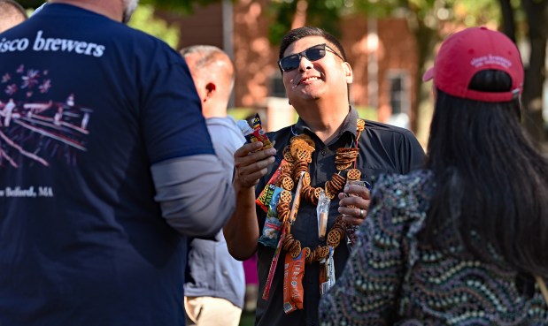 Center, with a pretzel, cheese and beef stick necklace is Peter Yoon of Northbrook during Northbrook Brewfest in Northbrook on Sept. 7, 2024. (Karie Angell Luc/Pioneer Press)