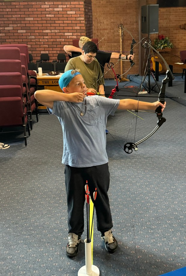 Caleb Bragon, 12, of Portage, and Donovan Sanchez, 14, of Portage, practice for their upcoming archery competition on Thursday, Aug. 29, 2024, at the Salvation Army in South Haven. (Deena Lawley-Dixon/for Post-Tribune)