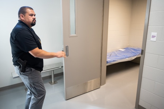 Chesterton Police Department Assistant Chief Cisco Rodriguez opens the door to a temporary holding area during a tour of the department's new building on Wednesday, Sept. 4, 2024. (Kyle Telechan/for the Post-Tribune)