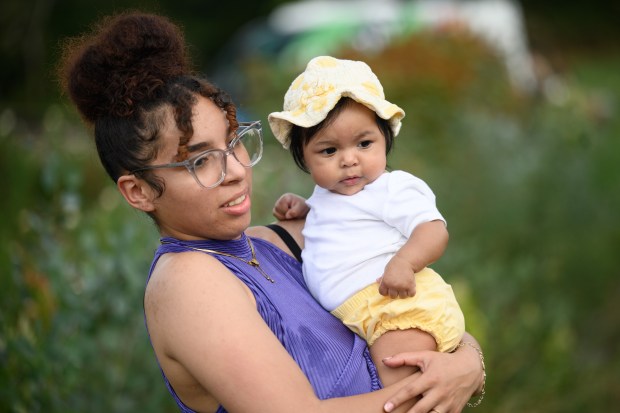 Hammond resident Elizabeth Rodriguez stands with her baby, Myrlianis Salgado-Milan, 5 months, during the FarmHer to Mama event at Hickory Hills Flower Farm on Friday, Sept. 20, 2024. (Kyle Telechan/for the Post-Tribune)