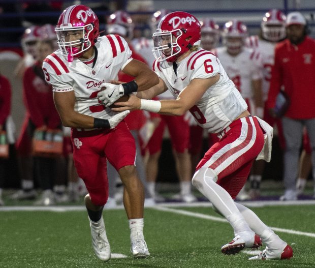 Crown Point's Noah Ehrlich (6) hands the ball to Larry Ellison during a game at Merrillville on Friday, Sept. 6, 2024. (Michael Gard/for the Post-Tribune)