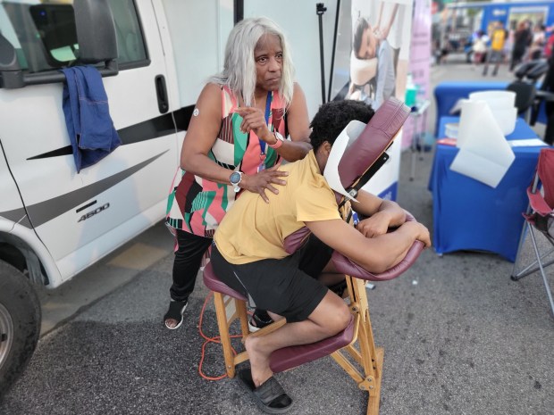 Jacqueline Fowler, owner of Stress Busters Inc., of Gary, works out the kinks in Jerrell Watson's, of Chicago, back during Gary's Fest in the First Sept. 21. The 21-year-old street fest highlights the city's businesses in the Miller neighborhood. (Michelle L. Quinn/Post-Tribune)