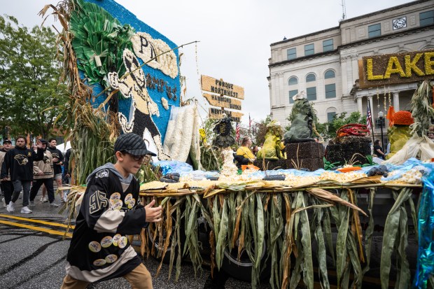 Purdue Northwest parade participants march around the school's corn-constructed float during the Valparaiso Popcorn Festival Parade on Saturday, Sept. 7, 2024. (Kyle Telechan/for the Post-Tribune)