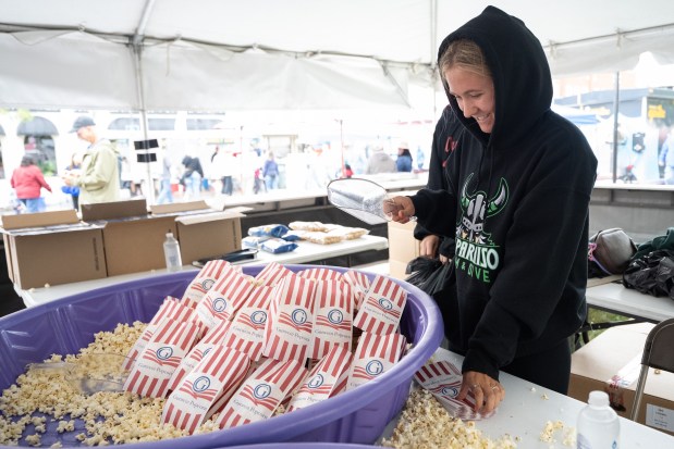 Washington Township Key Club member Alivia Goetz, 17, scoops popcorn into bags to be handed out during the Valparaiso Popcorn Festival on Saturday, Sept. 7, 2024. (Kyle Telechan/for the Post-Tribune)