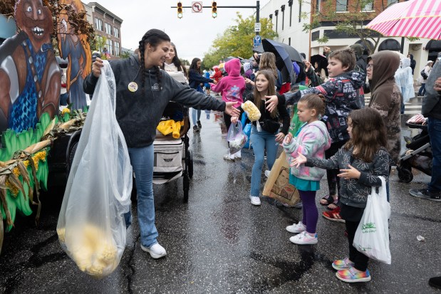 Terry's Discount Windows employee Olivia Klinger throws bags of popcorn to onlookers during the Valparaiso Popcorn Festival Parade on Saturday, Sept. 7, 2024. (Kyle Telechan/for the Post-Tribune)