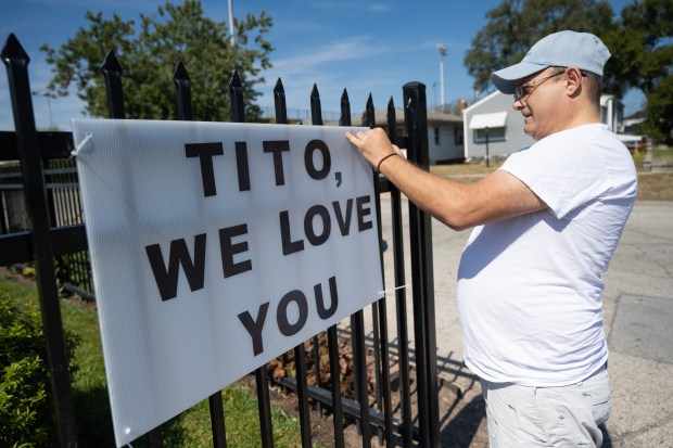 Gary resident Robert Prusynski hangs a sign in honor of the recently-passed Tito Jackson as fans gather at the Jackson family home in Gary to mourn the artist's death on Monday, Sept. 16, 2024. (Kyle Telechan/for the Post-Tribune)