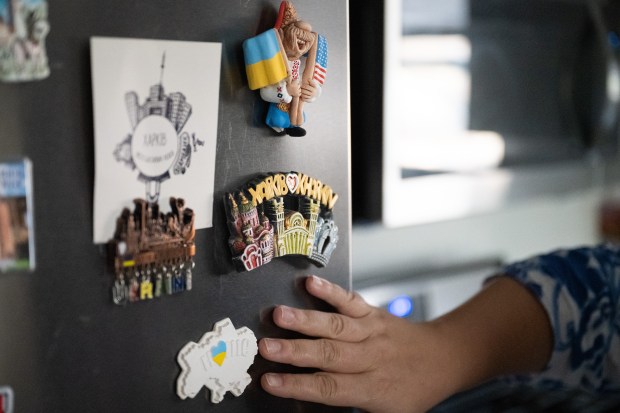 Crown Point resident Elmira Miocic, who moved to the U.S. from Ukraine four years ago, points out magnets from her home town, Kharkiv, on the fridge at her Crown Point home on Wednesday, Sept. 11, 2024. (Kyle Telechan/for the Post-Tribune)