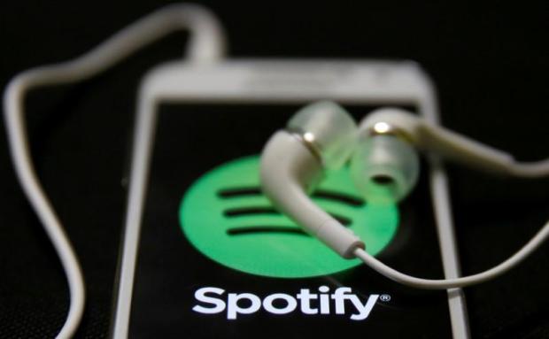 FILE PHOTO: Earphones are seen on top of a smart phone with a Spotify logo on it in this February 20, 2014 photo illustration. REUTERS/Dado Ruvic/Illustration/File Photo