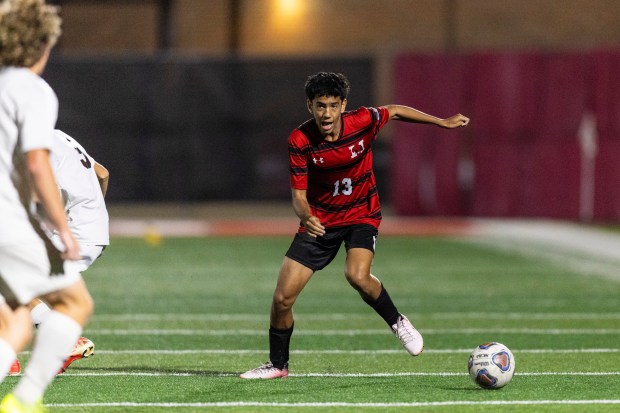 Marist's Matthew Pappalardo (13) works the ball by an Joliet Catholic defender during an East Suburban Catholic game in Chicago on Wednesday, Sept. 25, 2024. (Vincent D. Johnson / Daily Southtown)