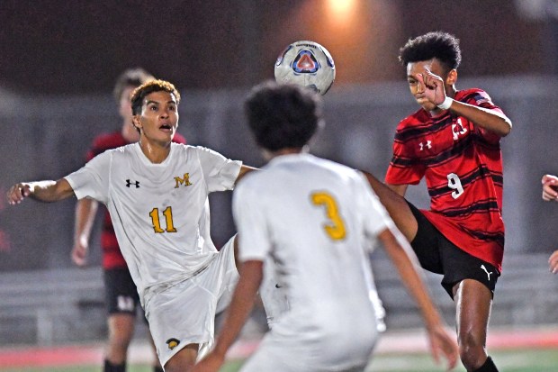 Marian Catholic Spartans Antonio Ferreira (11) and Marist RedHawks Jordan Easterling (9) battle for the ball during the second half of the varsity boys' soccer match on Wednesday, Sept. 18, 2024, in Chicago. (Patrick Gorski/for the Daily Southtown)