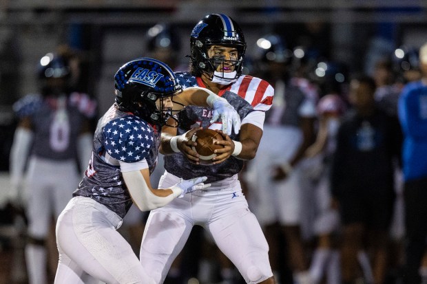 Lincoln-Way East's Jonas Williams, right, reads the defense before deciding whether to hand the bal off to Brody Gish against Homewood-Flossmoor during a Southwest Valley Blue game in Frankfort on Friday, Sept. 27, 2024. (Vincent D. Johnson / Daily Southtown)