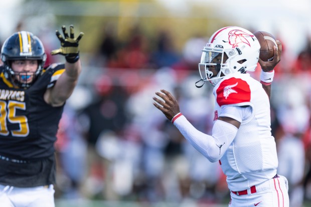 Homewood-Flossmoor's Randall McDonald, right, gets off a pass before Marian Catholic's Joaquin Mendez was able to disrupt the play during a nonconference game in Chicago Heights on Saturday, Sept. 7, 2024. (Vincent D. Johnson / Daily Southtown)