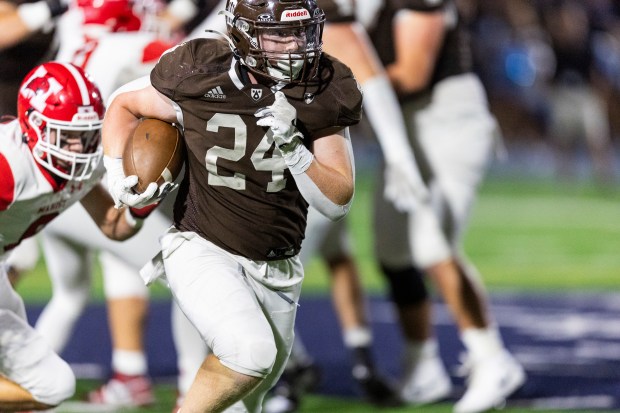 Joliet Catholic's Larry Stringham (24) breaks through the Marist line for a gain during a CCL/ESCC Green game in Joliet on Friday, Sept. 20, 2024. (Vincent D. Johnson / Daily Southtown)