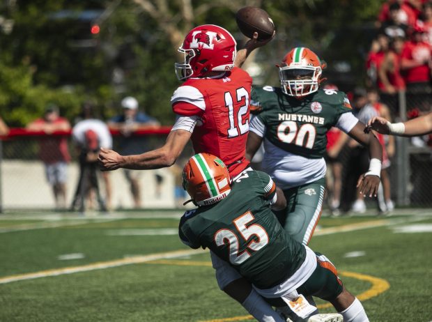 Morgan Park's Mekhi Hubbard (25) takes Marist's Jacob Ritter (12) down, but it wasn't soon enough as Ritter connected with Brendan Doran for a touchdown during a nonconference game in Chicago on Saturday, Aug. 31, 2024. (Vincent D. Johnson / Daily Southtown)