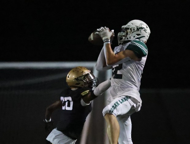 Oak Lawn strong safety Luke Mahoney (12) catches a pass for a touchdown during a South Suburban Red Conference football game at Richards High School in Oak Lawn on Friday, Sept. 20, 2024. (Talia Sprague / Daily Southtown)