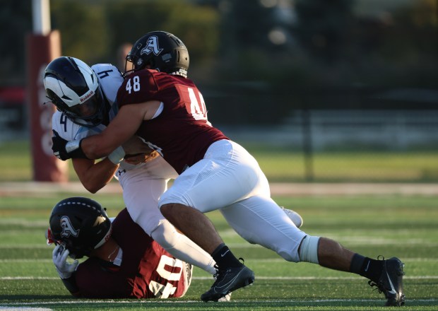 Reavis quarterback Jonathan Liesen (4) is tackled by Argo tight end Maciej Jarosz (48) during a South Suburban conference game at Argo High School in Summit on Friday, Sept. 13, 2024. (Talia Sprague / Daily Southtown)