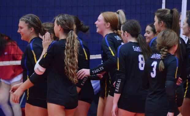 Katie Collopy, left, leads the team in celebration after putting down the final kill against Yorkville in Aurora on Sept. 18, 2024. (Jeff Vorva / Daily Southtown)