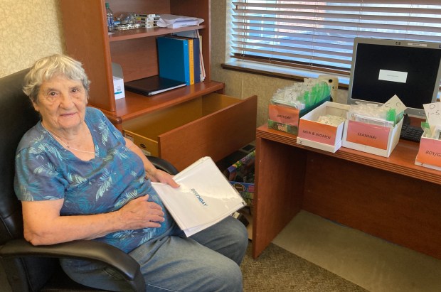 Rose Kirk, a resident at Peace Village in Palos Park, shows how greeting cards created by her group have been organized into categories ahead of a sale Thursday at Peace Village in Palos Park. (Melinda Moore/Daily Southtown)