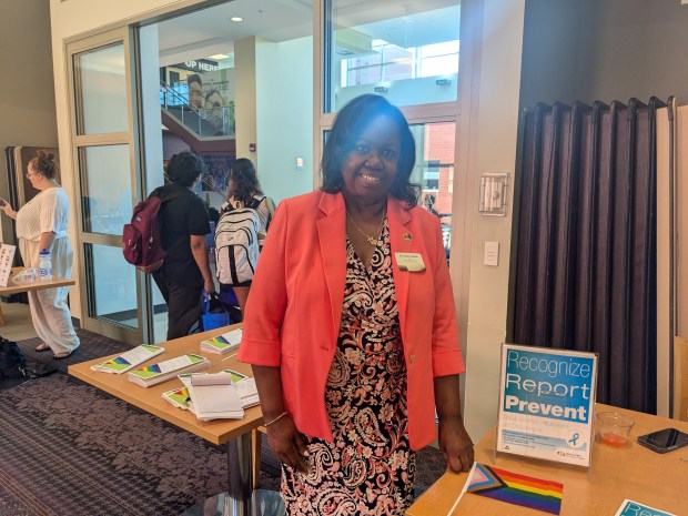 Jo Ann Jenkins, dean of Student Services at Moraine Valley Community College, hands out information about how to report discrimination and harassment incidents during a Rainbow Reception last week at the college in Palos Hills. (Janice Neumann/Daily Southtown)