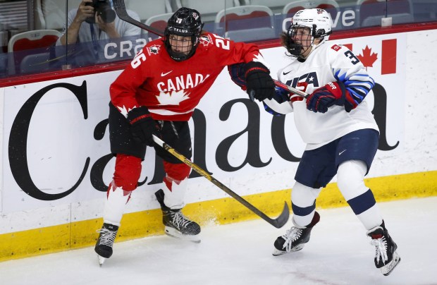 Canada's Emily Clark, left, checks the United States' Abbey Murphy during the first period of the IIHF Women's World Championship final in Calgary, Alberta on Tuesday, Aug. 31, 2021.