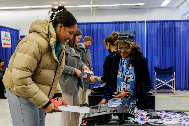 From right, Early voting official Cynthia Webb assists Jessica Lathan while she deposits her voting ballot at the Chicago Board of Elections' Loop Super Site the day before Illinois' primary Election Day Monday March 18, 2024 in Chicago.(Armando L. Sanchez/Chicago Tribune)