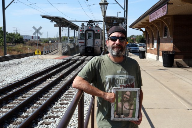 Phil Bentkowski holds a photo of his daughter Grace, 22, who was struck and killed by a train after getting off another train and walking across a set of tracks at the Hegewisch Metra station in Chicago in July. He is trying to get better warning and safety equipment installed at the station. (Terrence Antonio James/Chicago Tribune)