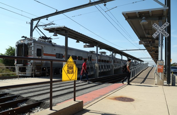 People cross a set of tracks that lack pedestrian gates as they leave the Hegewisch Metra station in Chicago on Sept. 13, 2024. Grace Bentkowski, age 22, was struck and killed by a train at the station in July. (Terrence Antonio James/Chicago Tribune)