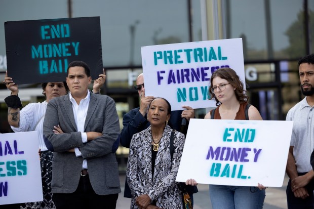 Supporters hold signs during a press conference regarding the SAFE-T Act, which eliminates cash bonds for certain offenses. (Erin Hooley/Chicago Tribune)