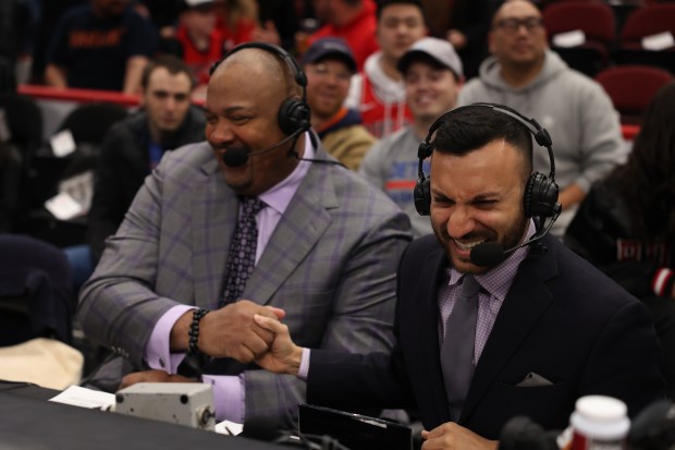 Adam Amin, right, laughs alongside Stacey King before the start of a Bulls game against the Detroit Pistons at the United Center in 2022. Amin and King will call Bulls games for the new network. (Michael Blackshire/Chicago Tribune)