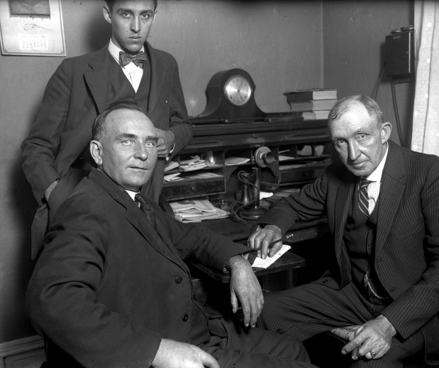 The Rev. Lawrence Hight, bottom left, is held at Mount Vernon, Illinois, and is charged with poisoning his wife in 1924. With Hight is Sheriff Grant Halcomb, right, and Deputy Sheriff Ronald Holcomb, standing. (Chicago Tribune historical photo)