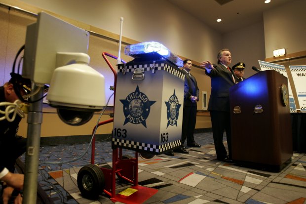 Then-Mayor Richard M. Daley speaks at a 2006 news conference about installing newer police surveillance cameras, shown at left, on Chicago street corners. The first models, at right, had flashing blue lights. (Kuni Takahashi/Chicago Tribune)