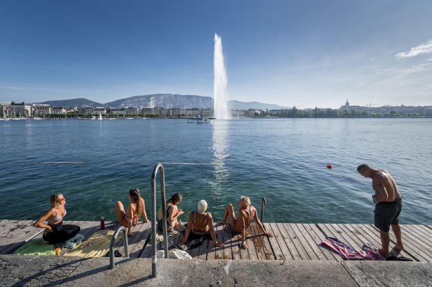 Lakegoers enjoy Switzerland's Lake Geneva at the Bains des Pâquis on Oct. 5, 2023, with Geneva's landmark fountain, Jet d'eau, in the background. (Fabrice Coffrini/Getty-AFP)