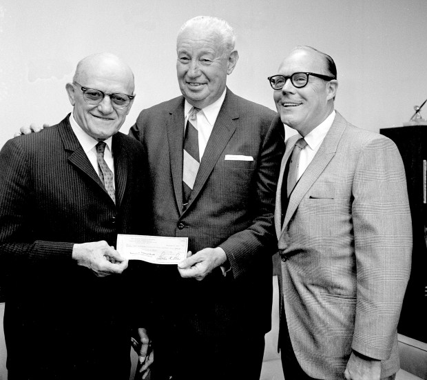 George Halas, left, owner and former coach of the Chicago Bears, and Anti-Superstition Society's "man of the year," presents a check to Ralph J. Schev, president of the 100 Club of Cook County, as Lester Lear, secretary of the society looks on, Oct. 1, 1968. The check is from the proceeds of a party held on Friday, Sept. 13, and is for the benefit of law enforcement officers' widows. (Edward Kitch/AP)