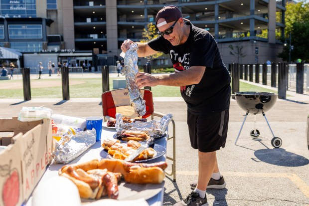 Tommy Jackovich plates meat at a tailgate outside the Guaranteed Rate Field before a game against the Los Angeles Angels in Chicago on Sept. 26, 2024. Sitting on a record-tying 120 losses, the Sox's next loss will make them the losingest team of the modern era. (Tess Crowley/Chicago Tribune)