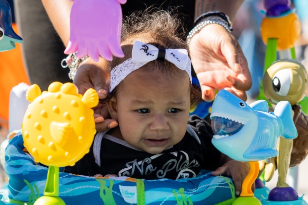 Maliyah Brewster, 6 mo., cries as a White Sox headband is placed on her head at a tailgate outside the Guaranteed Rate Field before a game against the Los Angeles Angels in Chicago on Sept. 26, 2024. Sitting on a record-tying 120 losses, the Sox's next loss will make them the losingest team of the modern era. (Tess Crowley/Chicago Tribune)